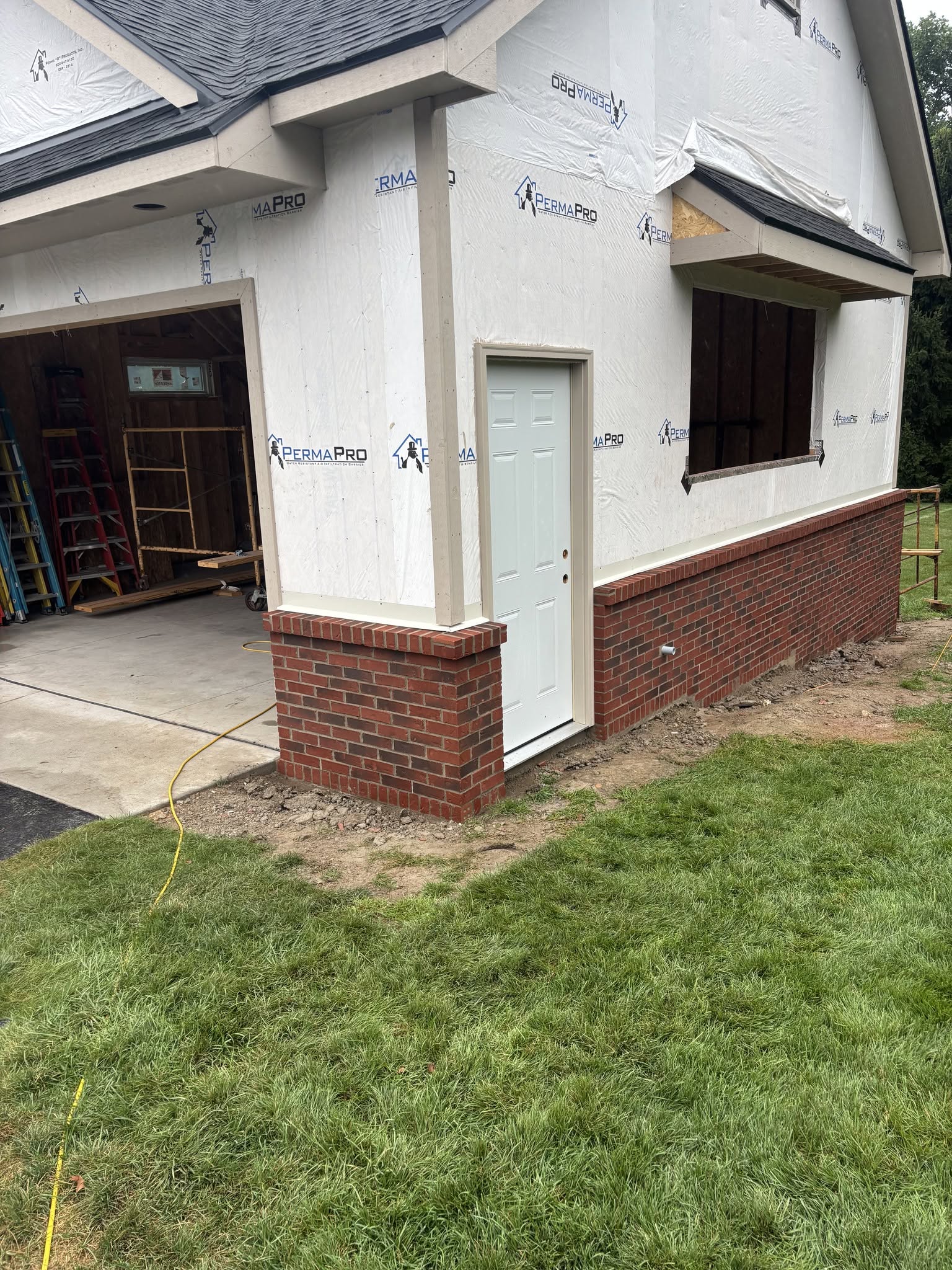 Garage addition with brick wainscoting and house wrap in Genesee County, Michigan Garage addition with brick wainscoting and house wrap in Genesee County, Michigan
